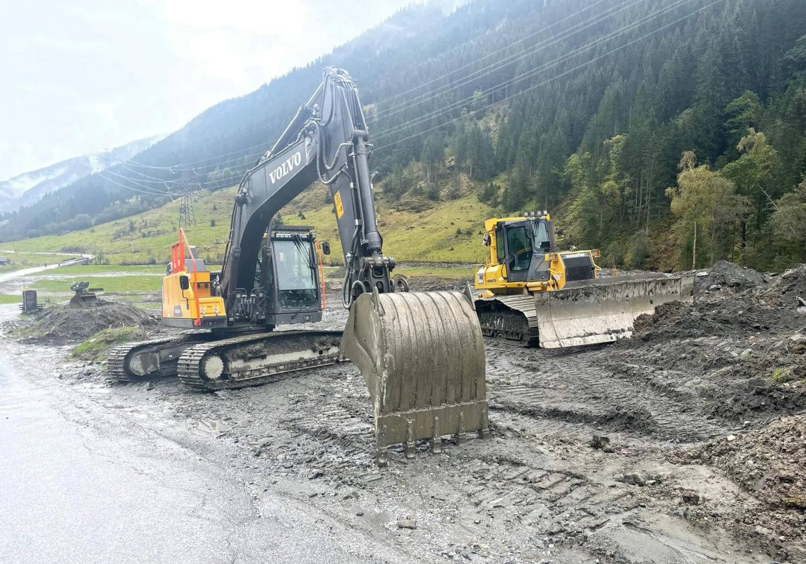 Kettenbagger und Laderaupe auf einer Baustelle im Talboden