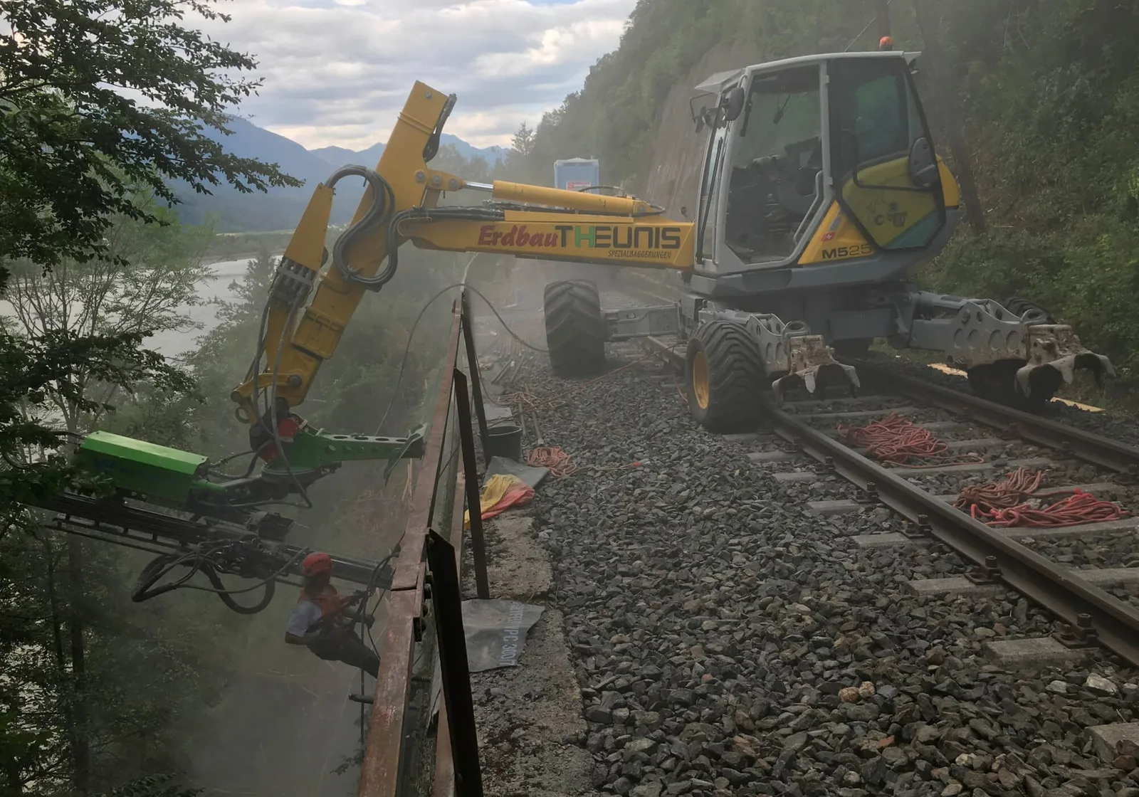 Schreitbagger mit Bohrgerät neben einem Bahngleis